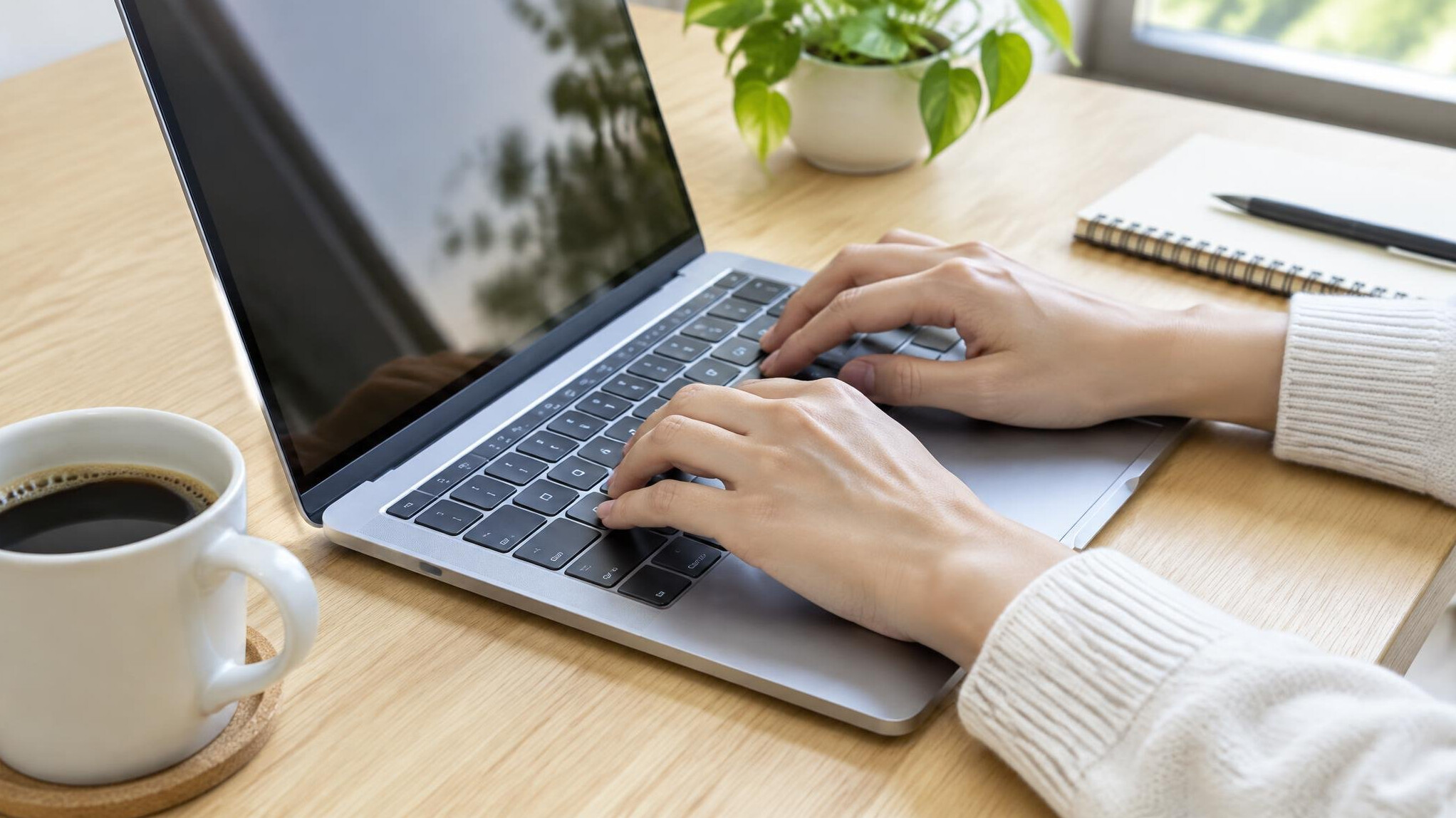 Hands typing on a laptop keyboard